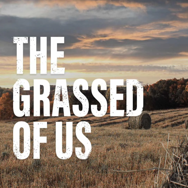 A field and text that reads: the grassed of us